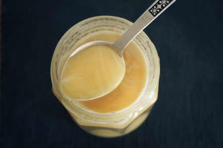 Yellow raw natural honey on silver spoonの写真素材