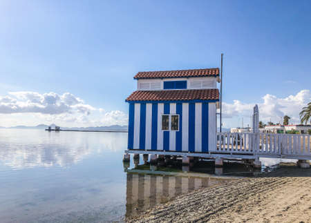 Blue and white stripes beach house above waterの写真素材