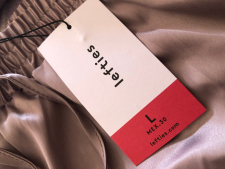 Alicante, Spain - October, 2023: White and red price Lefties tag Large size on silk beige fabric close upの写真素材