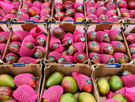 Alicante, Spain - March 25, 2025: Mango fruit in bright packaging in supermarketの写真素材