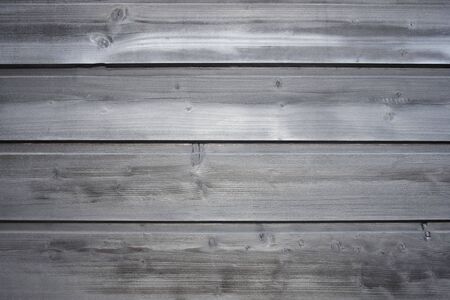 Old wooden surface of tightly nailed planks with cracks and knots. Grey background close-up....