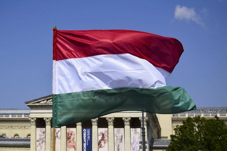 BUDAPEST, HUNGARY - MAY 2019: Close-up of single hungarian tricolor flag waving in the wind on the background of the Museum on heroes Square and blue sky. Flag of Hungary developing in the wind .のeditorial素材
