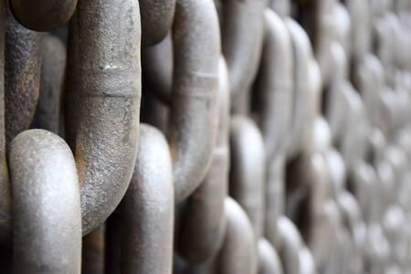 Rusty old brown Iron chains, background. Wall of hanging vertically massive chains. Close-up....