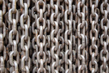 Rusty old brown Iron chains, background. Wall of hanging vertically massive chains. Close-up....