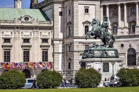 Vienna, Austria, May 2019: Equestrian monument to Prince Eugene of Savoy in front of the Hofburg building. In the background flags of different countries and tourists.のeditorial素材