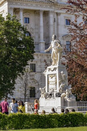 Tourists walk near the monument to Mozart, installed in Burggarten - former Imperial Garden. Statue is made of white marble. Architect Victor Tilgner. Austria, Vienna - may 2019.のeditorial素材
