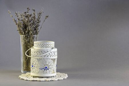 White openwork candlestick with aroma of candles and dry bouquet of lavender on gray background. Relaxation concept. Close-up. Selective focus. Copy space.の写真素材