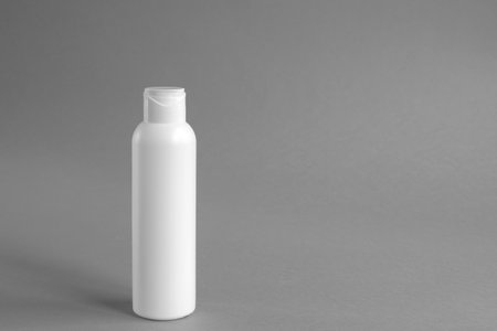 White plastic cosmetic lotion bottle mock-up with cap on gray background. Hygiene, Beauty and body skin care concept. Copy space.の写真素材