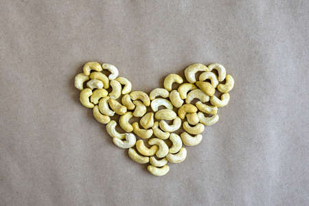 Heart made of cashew nuts, on gray craft paper. Close-up. Selective focus.の写真素材