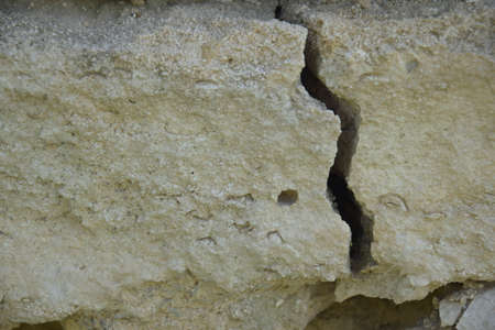 Big winding crack in wild shell stone masonry. Consequences of earthquake. Copy space. Close-up. Selective focus.の写真素材