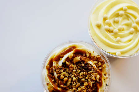 Two delicate sweet desserts made of sponge dough and custard. Delicious desserts in transparent glasses of British cuisine. Close-up. Top view. Copy space. Selective focus.の写真素材