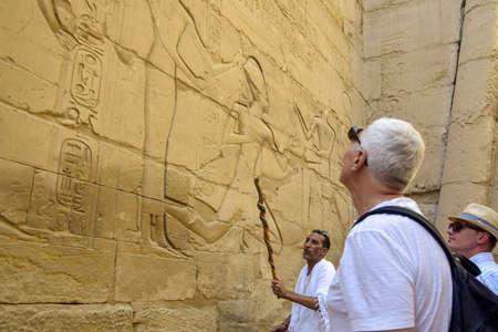 Tourists on an excursion to Karnak Temple. Beautiful Egyptian landmark with hieroglyphics and...