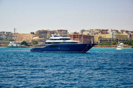 Big blue yacht on pier waiting for tourists for sea trip. Vacation on Red Sea, resort, holidays, leisure and adventure, travel. Shore is visible in background. Hurghada, Egypt - October 2021のeditorial素材