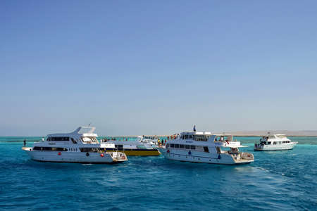 People relax on yacht sea on sunny day. Picturesque seascape with several yachts with vacationing tourists. Leisure on Red Sea, resort, holidays and adventure, travel. Hurghada, Egypt - October 2021のeditorial素材