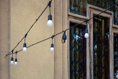 Street illumination decoration. Garland of light bulbs. Street stretch marks against background of...