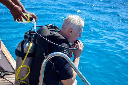 Scuba diver before diving. Diving lesson in open water. Male in scuba diving suit is preparing to dive into deep sea. Hurghada, Egypt - October 2021のeditorial素材