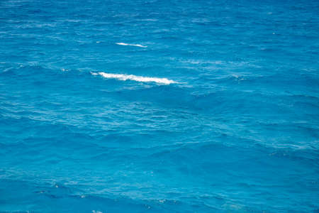 Abstract background. Waves of blue sea water. Copy space. Selective focus.