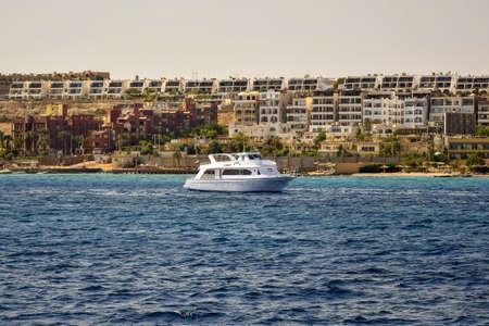 One moored white yacht waiting for tourists for sea trip near coastline of city. Vacation on Red Sea, resort, holidays, leisure and adventure, travel. Hurghada, Egypt - October 2021のeditorial素材
