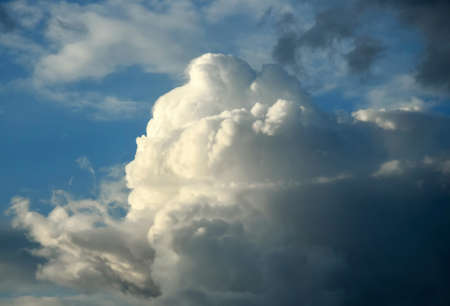 Picturesque sky with thunderstorms cumulus clouds. Blue sky with big clouds, backlit by sun. Air...