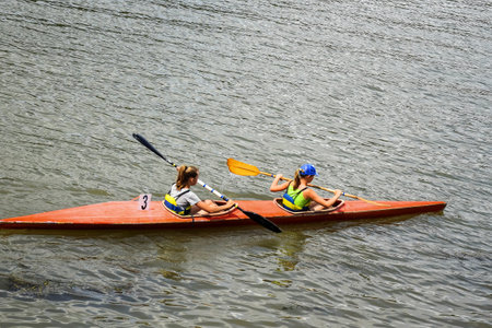 Two young girl athletes are sailing canoe on river, controlling oars. Active outdoor sports training. copyspace. Chisinau, Moldova - July 2021のeditorial素材