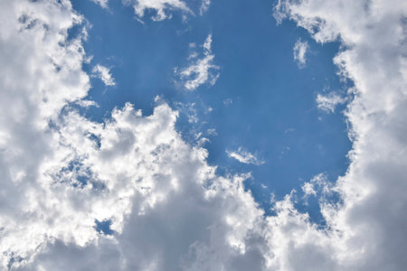 Beautiful cloudy sky. Blue sky with lots of white fluffy clouds, natural background, full frame. Copy space, place for text. selective focus.の写真素材
