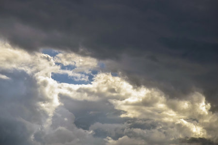 Picturesque thunder sky with cumulus clouds. Stormy sky with big clouds, backlit by sun. Air clouds...