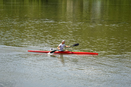 One athlete are sailing canoe on river, controlling oars. Active outdoor sports training. side view....