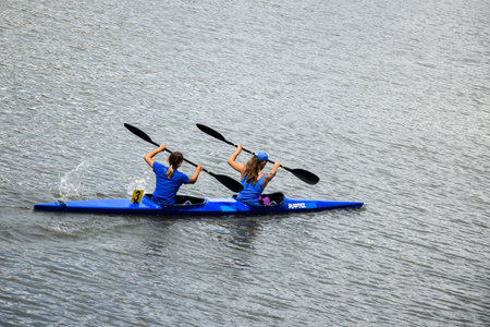 Two young girl athletes are sailing canoe on river, controlling oars. Active outdoor sports training. side view. copyspace. Chisinau, Moldova - July 2021のeditorial素材
