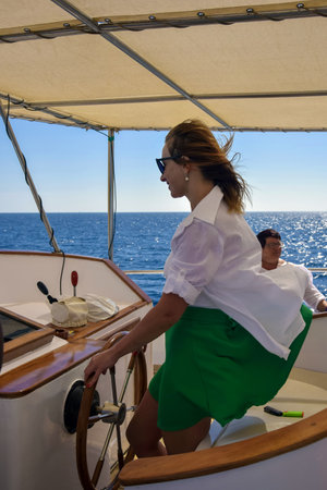 Young woman at the helm of yacht. Recreation on Red Sea, resort, holidays and adventure, travel....