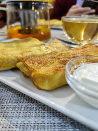 Fried pancakes stuffed with meat and sour cream. Placed on a rectangular white plate. close-up. selective focus.の写真素材