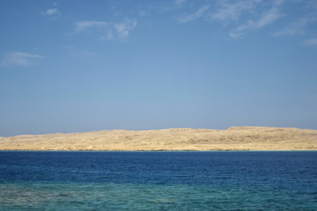 Vacation, travel, holiday, trip to Egypt. View from Red sea to deserted sandy island against clear blue sky. Copy space. Selective focus.の写真素材