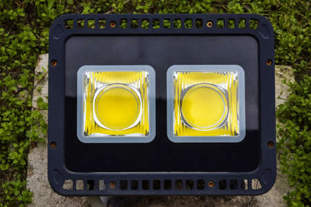 Modern LED twin spotlight against green grass. Lighting equipment, outdoor Floodlight. Copy space for text.の写真素材