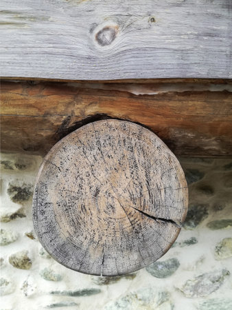 End of round cracked log, beam in roof area of ââââold stone building. Close-up. Selective focus. Copy space for text.の写真素材