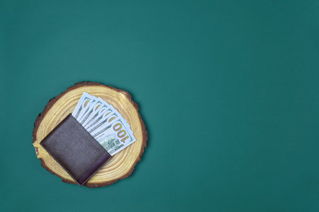 Banknotes of different denominations randomly lie on wooden saw. American national currency. Cash...