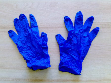 Pair of blue disposable medical latex gloves on light background. Virus protection remedies. Top view. Close-up. Selective focus.の写真素材