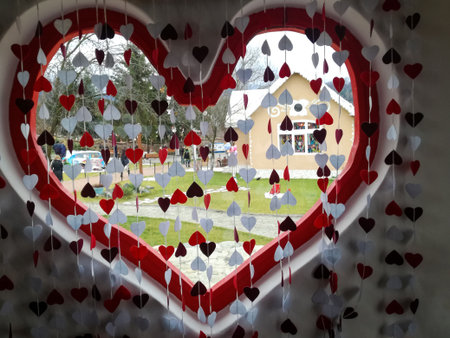 Street view through heart-shaped window decorated with small hearts. Celebrating Valentine's Day. Close-up.の写真素材