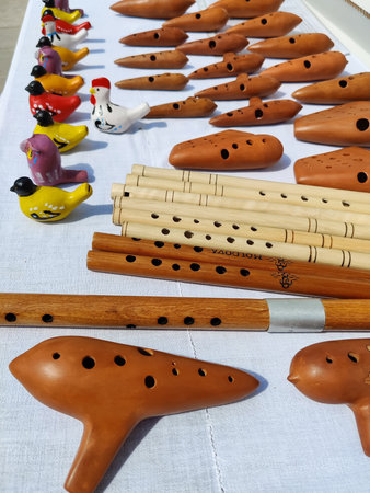 Wooden whistle flutes and bird-shaped whistles on street stall. They are traditional musical instruments and souvenirs for tourists. Close-up.の写真素材