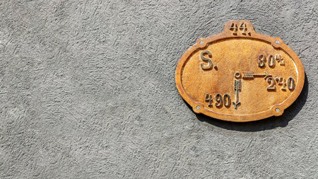 Old plate of fire hydrant on wall of ancient building in medieval European city. Close-up. Copy space.の写真素材