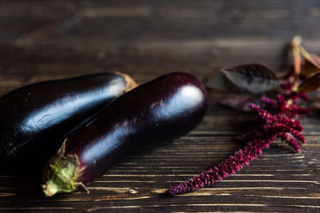purple vegetables on black wooden boards eggplants, amaranths twig