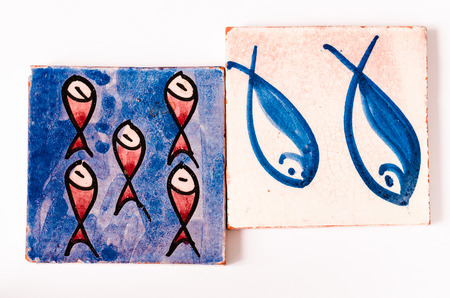 tiles with fishes drawing on it over whiteの写真素材