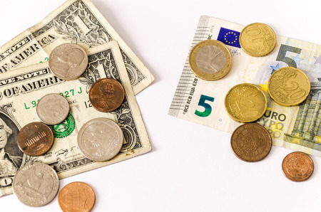 two group of bills and coins of euros and dollars, lay over white, face opposingの写真素材
