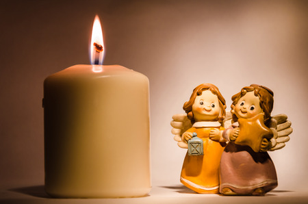 still life with a little angel and a candle, symbol of hope and christmasの写真素材