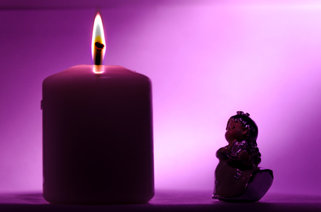 still life with a little angel and a candle, symbol of hope and christmasの写真素材