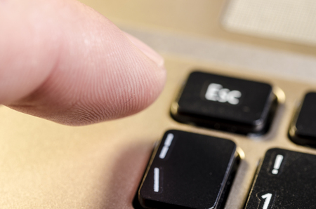close up of an index that is going to press esc on a computer keyboardの写真素材