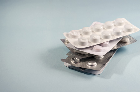 blister of pills. pharmaceutical. disease remedy. over blue background with copy space on the leftの写真素材