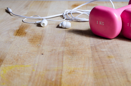 stil life with pink weights, earphones and a yellow tape measrument. fitness. conceptの写真素材