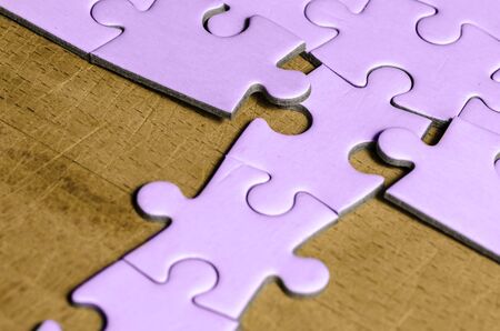 white jigsaw/puzzle with a row in wrong position, over  wooden table background, symbol of problem solving and new visionの写真素材