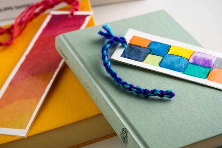 colorful bookmarks on a closed yellow andf green book. education. reading.