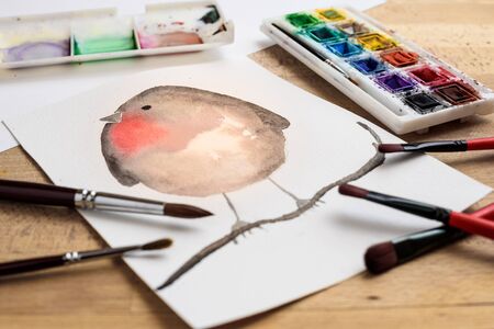 bird made with watercolor painting on paper with paint palette and paintbrushesの写真素材