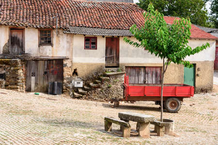 square in the village of Montesinho with a red cart, Montesinho, Braganca, Portugalの写真素材